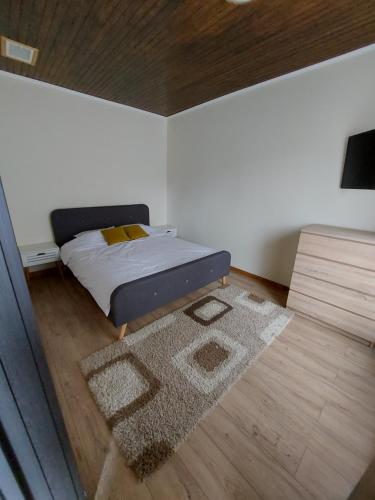 a small bedroom with a bed and a rug at ALEXANDER Ski Lake View in Beliş