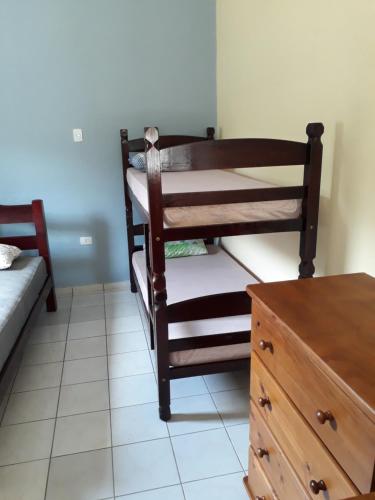 1 dormitorio con litera y tocador de madera en CASA DO PESCADOR, en Peruíbe
