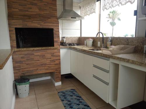 a kitchen with a sink and a counter top at Aps de frente com sacada ou terraço a 10 minutos do Aeroporto in Porto Alegre