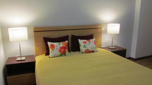 a bedroom with a bed with two lamps on it at Solar Guesthouse Olival da Vinha in Castelo de Paiva