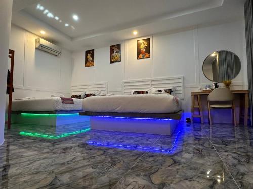 a bedroom with two beds and a desk and a table at SEA SAND RESORT in Kampot