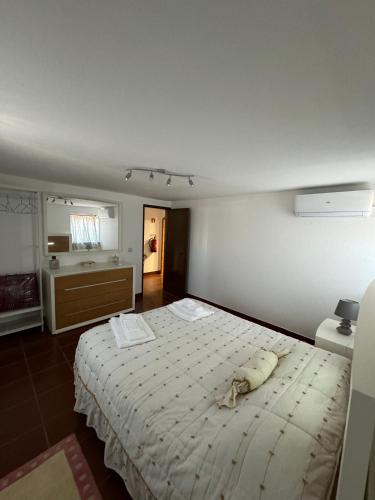 a bedroom with a large bed and a bathroom at Casa do Terreiro in São João de Tarouca
