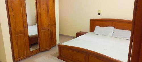 um quarto com uma cama e um espelho em Appartement meublé deux chambres salons em Cotonou