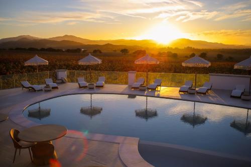 a pool with chairs and a sunset in the background at Villa Agostina in Murta Maria