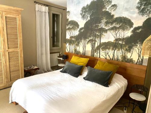 une chambre avec un lit blanc avec des oreillers jaunes dans l'établissement Villa des Alpilles, à Eygalières