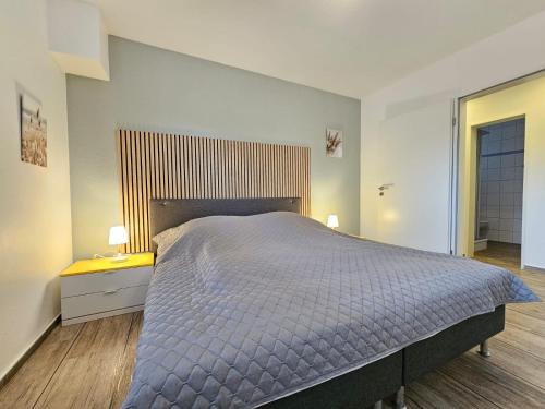 a bedroom with a large bed and a wooden floor at Mienhus Apartments Ferienwohnung Beeke in Norden