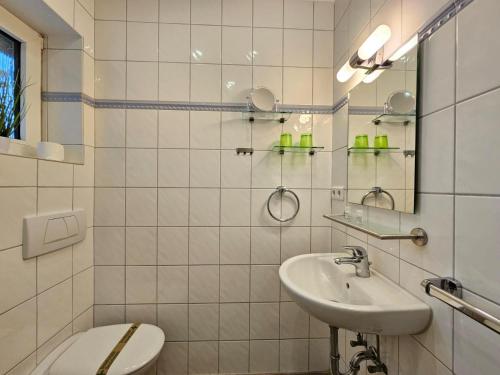 a white bathroom with a sink and a toilet at Mienhus Apartments Ferienwohnung Beeke in Norden