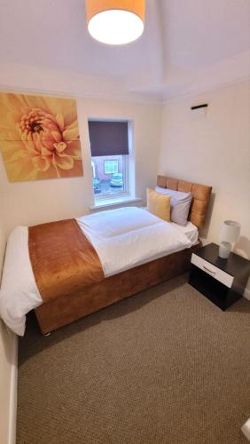 1 dormitorio con 1 cama grande y una pintura en la pared en Three Bed House with free on-site parking Sleeps 5 en Warrington