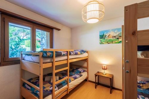 a bedroom with bunk beds and a window at Arnica 1 - 6 pers - piscine in Nendaz