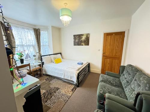 a small bedroom with a bed and a couch at Big Private Room In Town Centre in Eastleigh