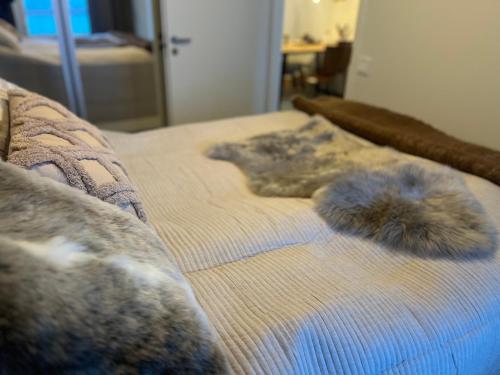 a bed with two fuzzy pillows on top of it at 2 Room / Central Railway / Free parking in Seinäjoki