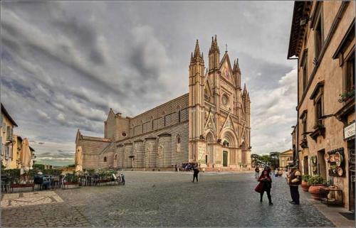 a church with a large building with a clock tower at Casa Vacanze Emmanuele in Porano