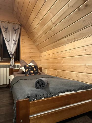 a bedroom with a bed in a wooden room at Janoś pokoje gościnne in Białka Tatrzańska