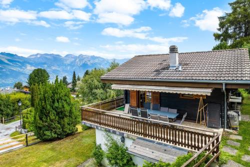 a house with a deck and mountains in the background at Darjean - 8 pers - belle vue in Plan Fey