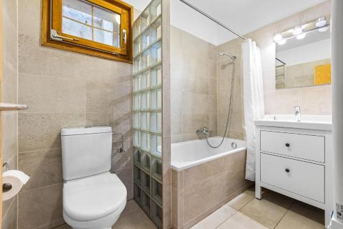 a bathroom with a toilet and a sink and a tub at Les 4 Abeilles - 6 pers - bien amenage in Nendaz