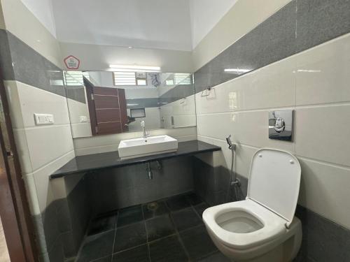 a bathroom with a toilet and a sink at OYO SAR Residency in Nanjangūd