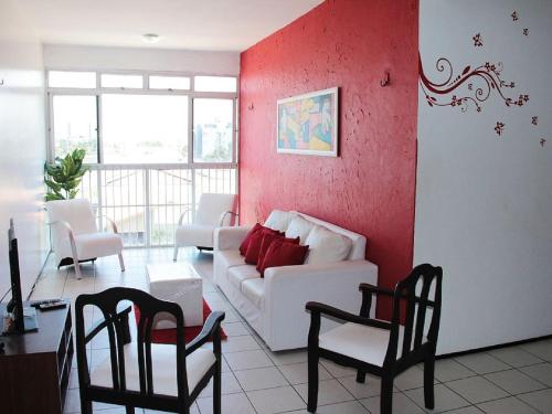 a living room with a white couch and red walls at Apartamento Mobiliado AptCE in Fortaleza