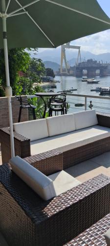 a white couch with an umbrella on a patio at Casa Martureza in Angra dos Reis