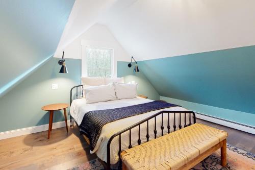 1 dormitorio con cama y banco. en Marble Farm, en Waitsfield