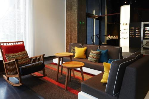 a living room with a couch and chairs and a table at Hôtel Alt Montréal in Montréal