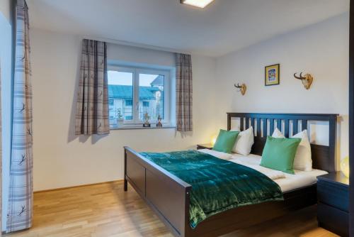 1 dormitorio con 1 cama grande con almohadas verdes en Apartment Wilder Kaiser en Kitzbühel