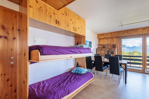 a room with bunk beds and a table with chairs at Chaedoz 21-2 - 4 pers - au calme in Nendaz
