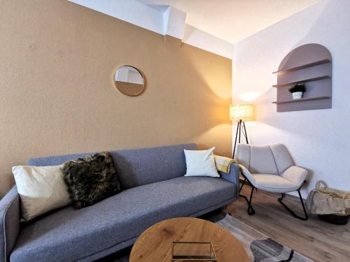 a living room with a blue couch and a chair at BohnApartments Junior SUITE Blume 14 - Nähe Dom - WLAN in Erfurt
