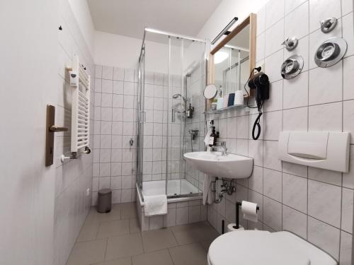 uma casa de banho com um lavatório e um chuveiro. em BohnApartments Junior SUITE Blume 14 - Nähe Dom - WLAN em Erfurt