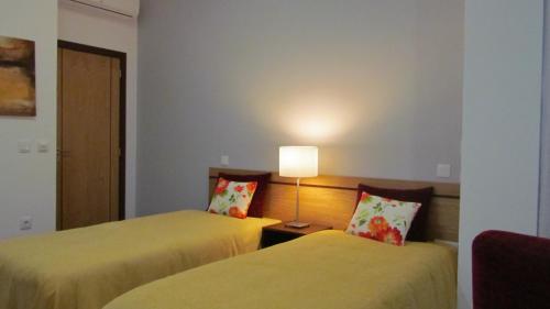 a hotel room with two beds and a lamp at Solar Guesthouse Olival da Vinha in Castelo de Paiva