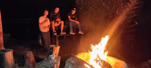 a group of people sitting around a fire at Casa Encuentro Ecolodge, Outdoor Gym and Yoga in Guatapé