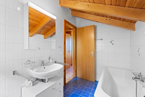 ein Badezimmer mit einem Waschbecken und einer Badewanne in der Unterkunft Felicitas - 7 pers - pres du centre in Nendaz