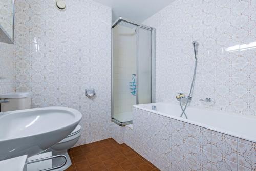 a bathroom with a shower and a toilet and a sink at Quille du Diable 46 - 4 pers - piscine in Nendaz