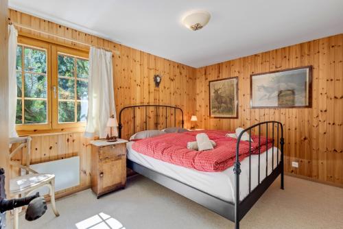 a bedroom with a bed with a red comforter at Gisele - 8 pers - pres des pistes in Nendaz