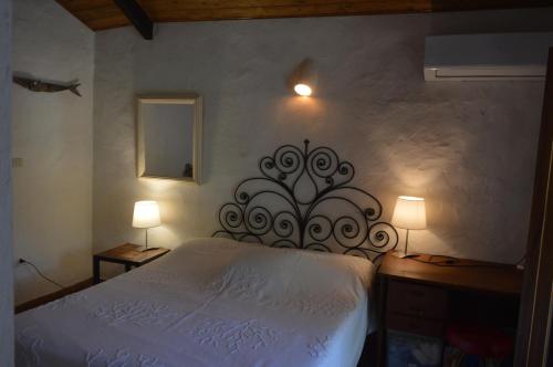 a bedroom with a white bed and two lamps at Villa Janas in San Teodoro