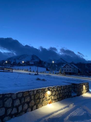 a stone wall in the snow at night at Portes du Soleil - Zabljak in Žabljak