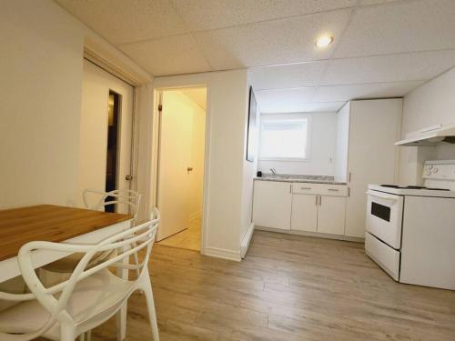 a kitchen with a table and a white stove top oven at Cozy 1BR in Vieux-Longueuil +parking 14min Downtown in Longueuil