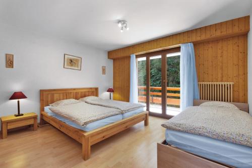 a bedroom with two beds and a window at Quille du Diable 34 - 4 pers - piscine in Nendaz