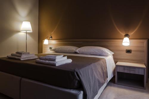 a bedroom with a bed with towels on it at B&B SALento in San Cesario di Lecce