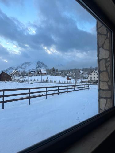a view of a snow covered field from a window at Portes du Soleil - Zabljak in Žabljak