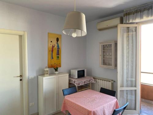 a dining room with a table and a pink table and chairs at Bright apt with views and terrace in Florence