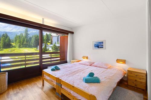 a bedroom with a bed and a large window at Rosablanche B12-B13 - 4 pers - au pied des pistes in Siviez