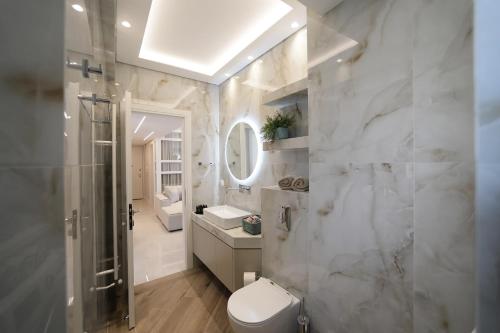 a bathroom with a toilet and a sink and a shower at Sam Casa Luxury Living in Kastoria