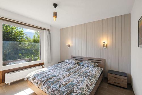 een slaapkamer met een bed en een groot raam bij Balcon des Alpes 02 - 4 pers - au calme in Nendaz