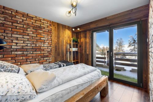 a bedroom with a brick wall and two beds at Dents-Rousses D2 - 4 pers - Siviez in Siviez