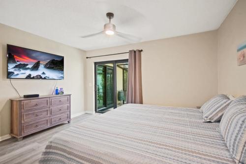 a bedroom with a bed and a ceiling fan at 2 Bed/2 Bath Beach Condo in St. Augustine