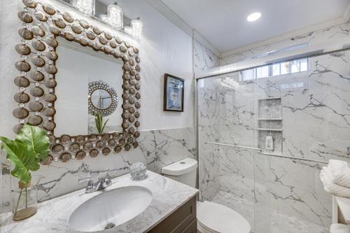 een witte badkamer met een wastafel en een spiegel bij Los Angeles Apartment with Large Outdoor Patio! in Los Angeles