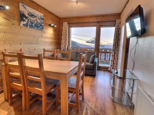 une salle à manger avec une table, des chaises et une télévision dans l'établissement Charmant 3 Pièces à 100m des Pistes, Idéal Famille avec Balcon, Animaux Acceptés - FR-1-182-199, à Les Allues