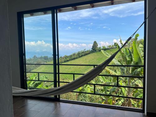 a hammock in a room with a view of a field at Orquideas 3 in Jericó