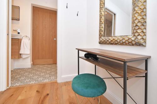 a bathroom with a table and a green stool at Chapel House, Where Comfort Meets Convenience - BOOK NOW! in Sandbach