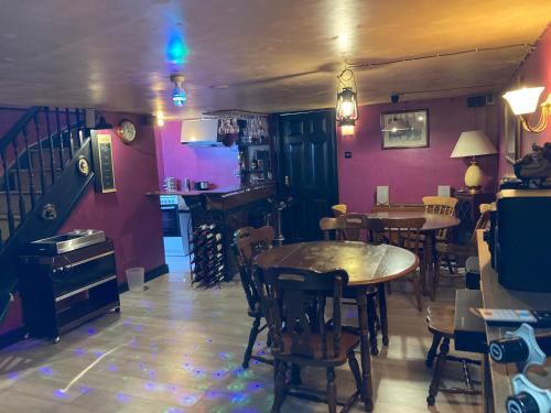 a dining room with tables and chairs and purple walls at B4-Jacks Court in Stalybridge